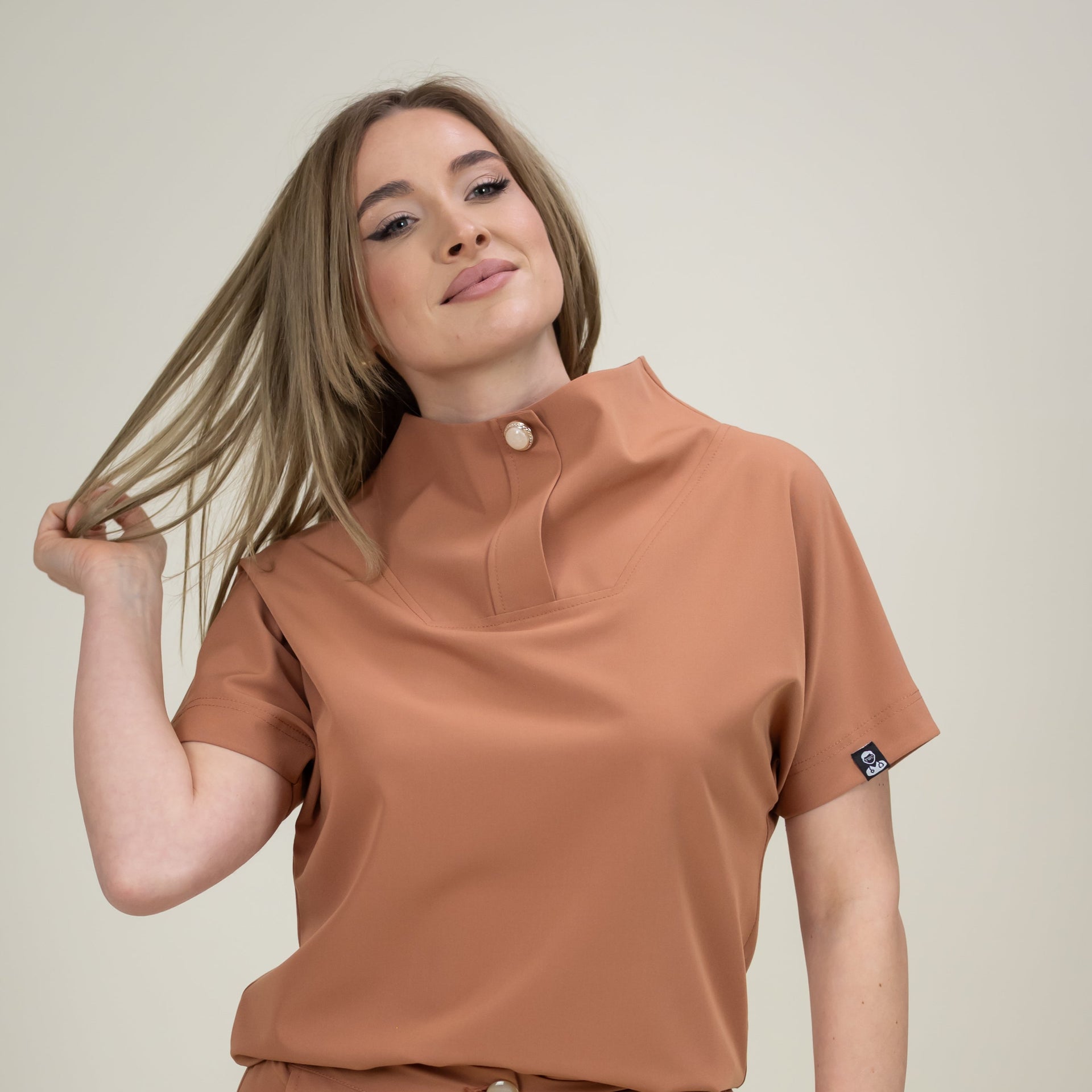 Woman wearing a brown outfit with a plain background